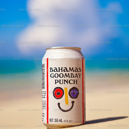 Bahamas Goombay Punch beverage sits on sandy beach in The Bahamas.