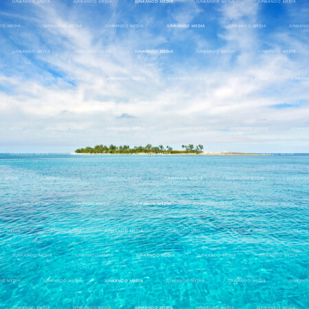 A Bahamian island sits in calm water surrounded by stratus cloud formation.