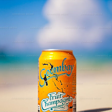 Goombay Fruit Champagne can of soda on a sandy beach in The Bahamas.
