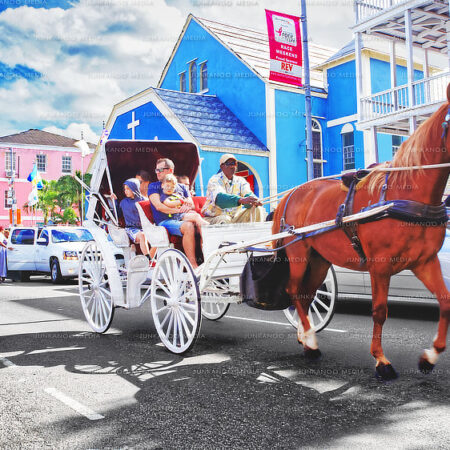 A horse drawn carriage pulls tourists and a driver down Shirley street in front of Zion Baptist Church.