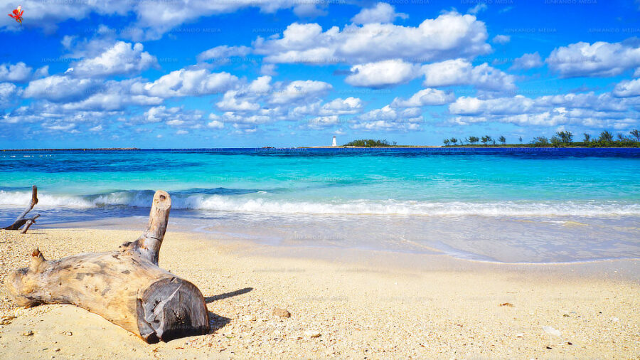 A beach in The Bahamas with white puffy clouds floating above.