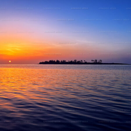 The setting sun next to an island in The Bahamas.