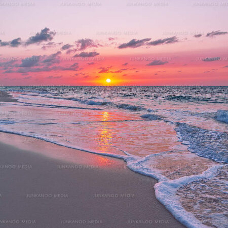 Ocean lapping Bahamian shore at sunset.
