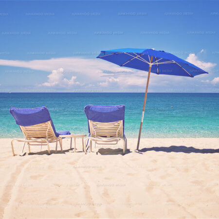 Two chairs and beach umbrella on a glorious afternoon in The Bahamas.