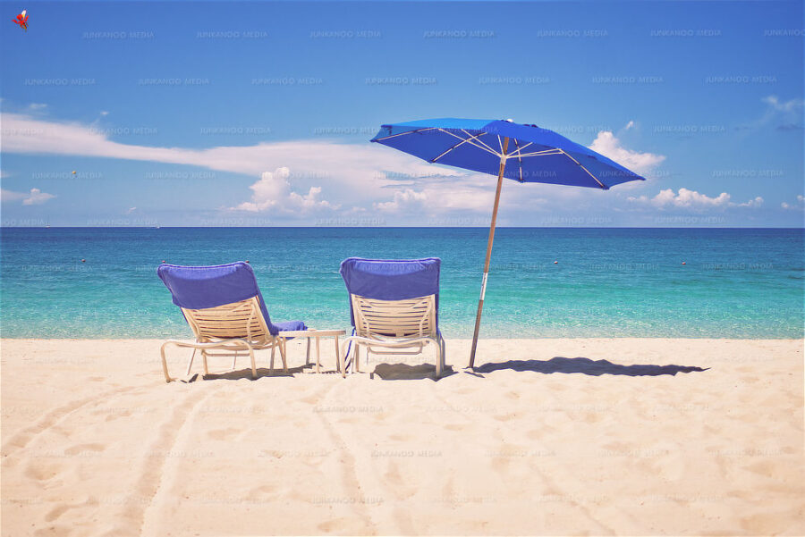 Two chairs and beach umbrella on a glorious afternoon in The Bahamas.