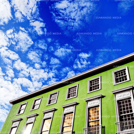 View of Norfolk House, a green building with Colonial style glass windows in Nassau, Bahamas