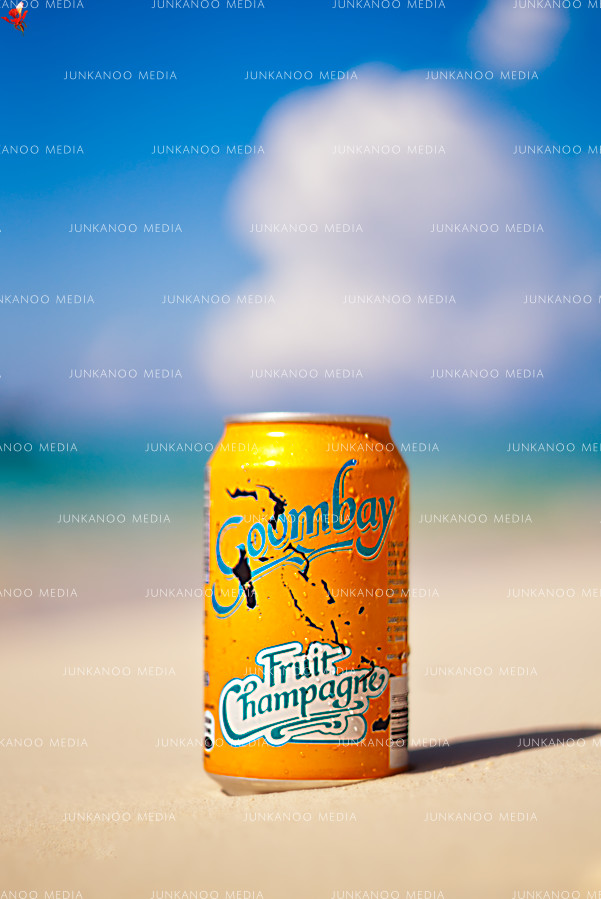 Goombay Fruit Champagne can of soda on a sandy beach in The Bahamas.