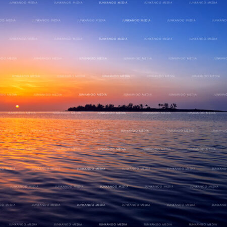 The setting sun next to an island in The Bahamas.